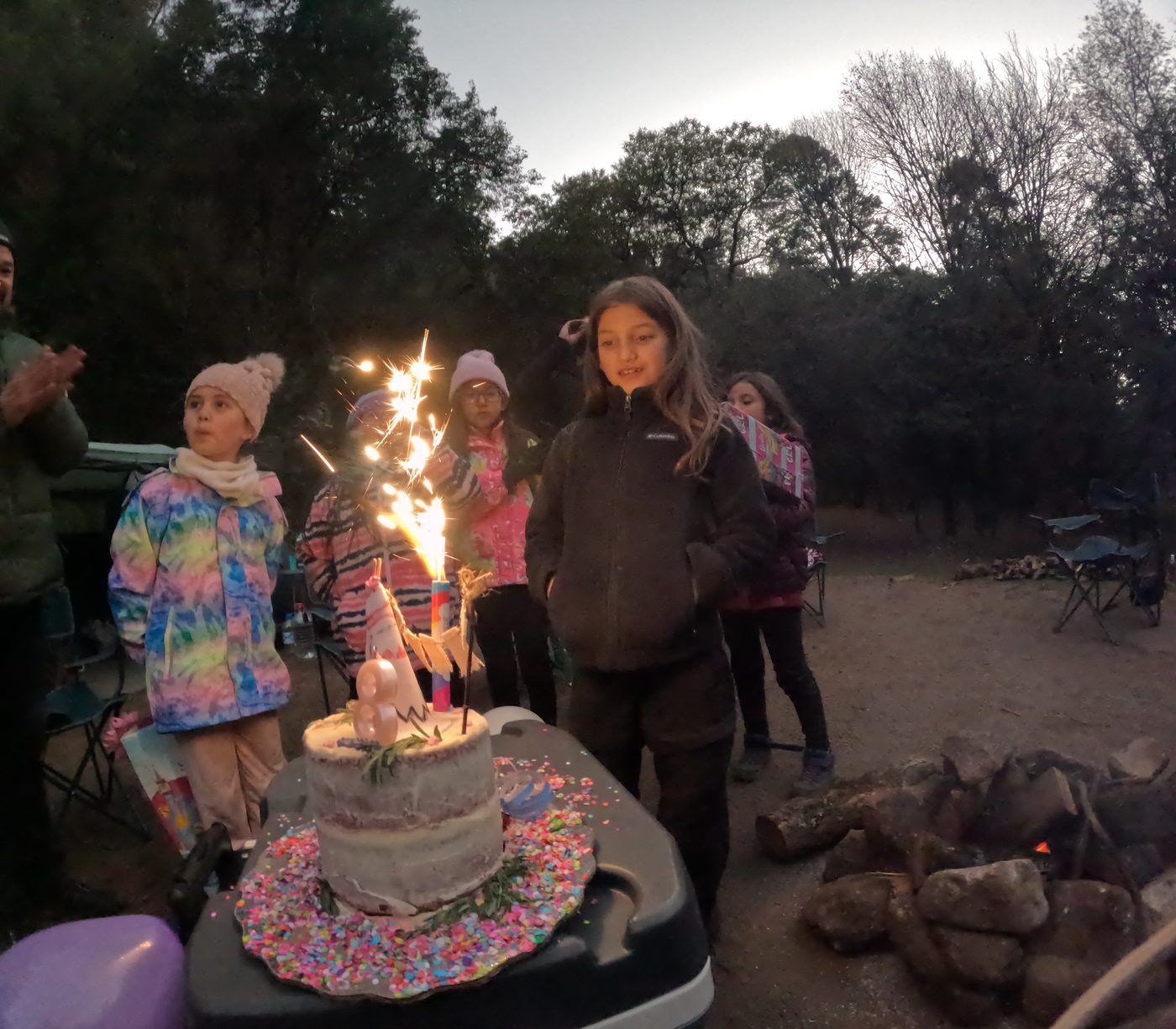 Niñas celebrando un cumpleaños con pastel y luces de bengala